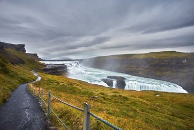 Scenic view of waterfall against sky