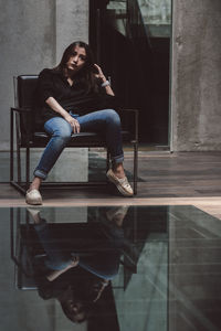 Full length of woman sitting on staircase