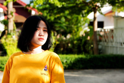 Portrait of woman standing against plants
