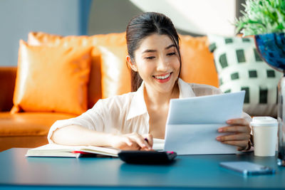 Portrait of businesswoman using laptop while sitting on table