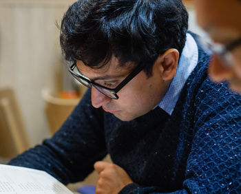 High angle view of mid adult man reading book while sitting at home