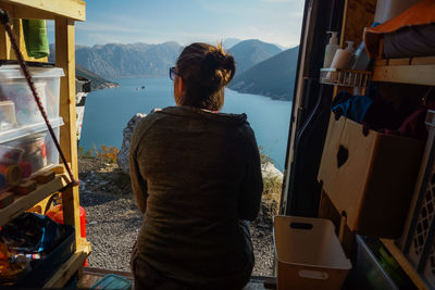 Rear view of woman sitting at doorway