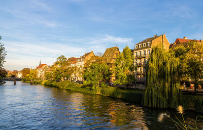 River flowing amidst buildings against sky