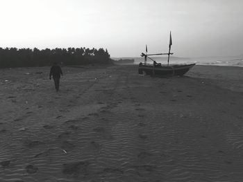 Silhouette man on beach against sky