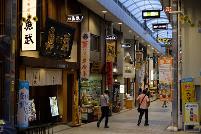 People walking on illuminated store