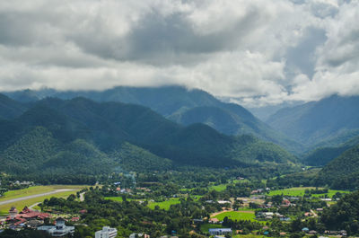 Scenic view of townscape and mountains against sky