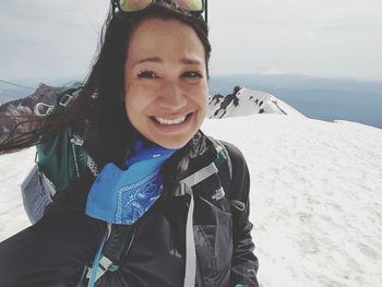 Portrait of smiling young woman standing on snow