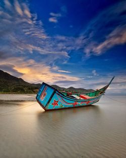 Boat in sea against sky during sunrise