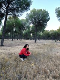 Side view of couple sitting on field