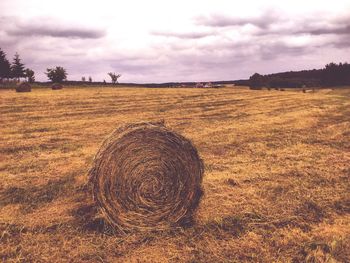 Hay bales on field against sky