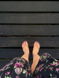 Low section of woman standing on boardwalk
