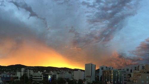 Buildings against cloudy sky at sunset