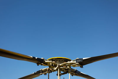 Close-up of helicopter propeller against blue sky