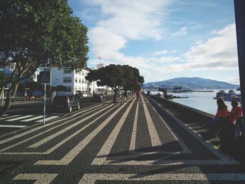 People on road in city against sky