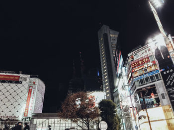 Low angle view of illuminated buildings against sky at night