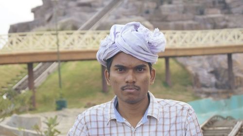 Portrait of man wearing turban against footbridge