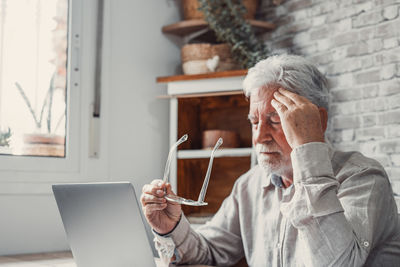 Side view of woman using mobile phone while sitting at home