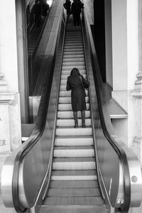 Rear view of man walking on stairs