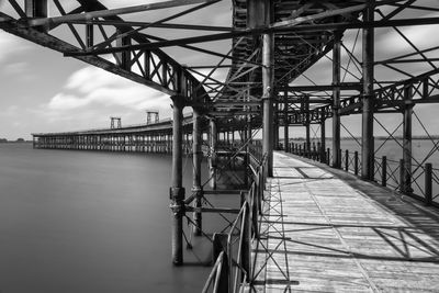 Bridge over river against sky with black and white