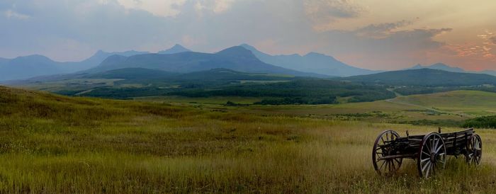 Scenic view of field and mountains against sky