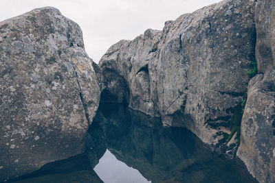 Rock formations by mountain against sky