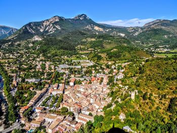 High angle view of houses and mountains against clear blue sky