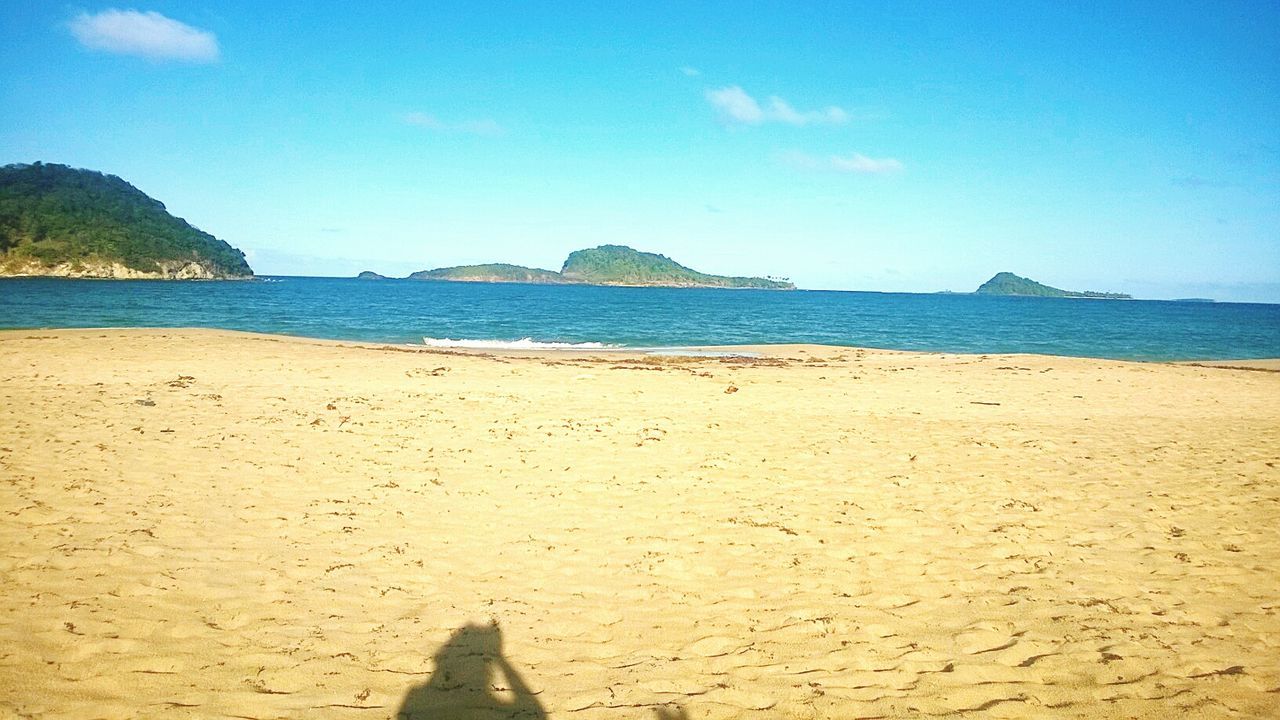 sea, water, beach, horizon over water, blue, tranquil scene, sky, scenics, tranquility, beauty in nature, shore, nature, sand, mountain, idyllic, day, coastline, sunlight, outdoors, incidental people