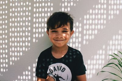 Portrait of smiling boy against wall