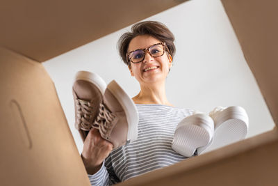 Portrait of young woman sitting on bed at home