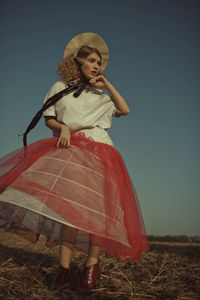 Low angle view of woman wearing costume standing against clear sky