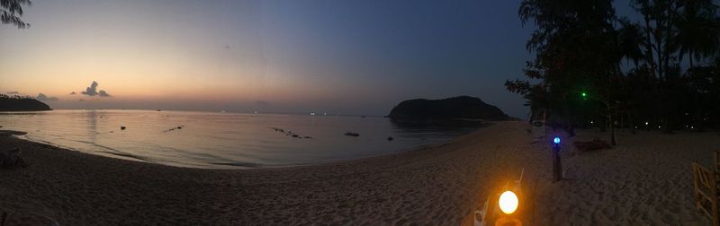 Panoramic view of beach against sky at sunset