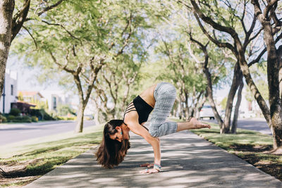 Woman of mexican ethnicity and middle age 35-39 years doing a crow yoga pose in full length in a pat