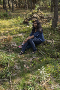 Young woman sitting in forest