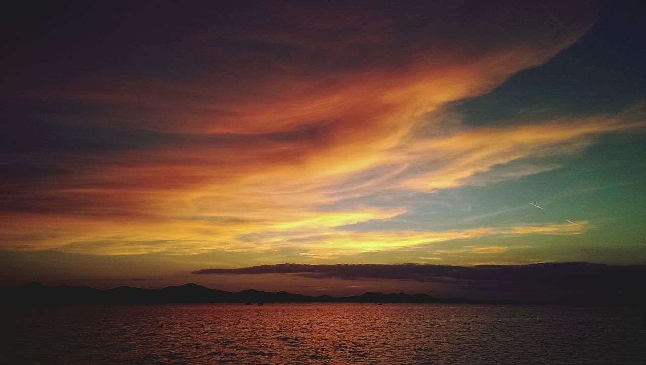sunset, scenics, tranquil scene, tranquility, beauty in nature, sky, water, mountain, cloud - sky, waterfront, idyllic, nature, sea, cloud, orange color, silhouette, cloudy, dramatic sky, mountain range, dusk