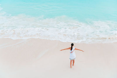 Rear view of woman standing on beach