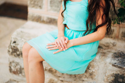 Midsection of woman sitting outdoors