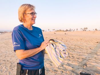 Woman standing on beach against clear sky