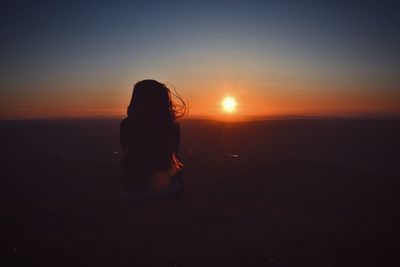 Silhouette woman standing at sunset