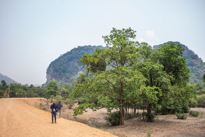 Tourists walking on grassy landscape