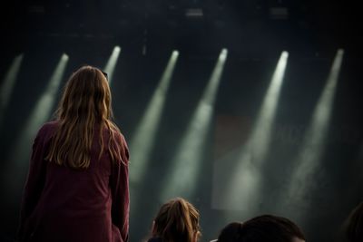 Rear view of women standing at music concert