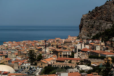 View over the tiled roofs of cefalu in sicily with the horizon of the mediterranean sea, background.