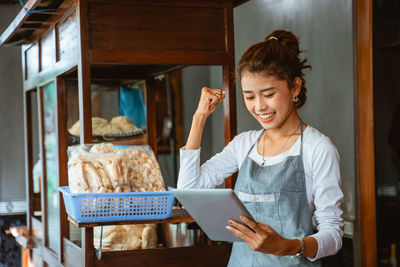 Young woman using mobile phone while sitting at home