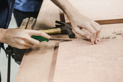 Cropped image of carpenter making furniture in carpentry workshop