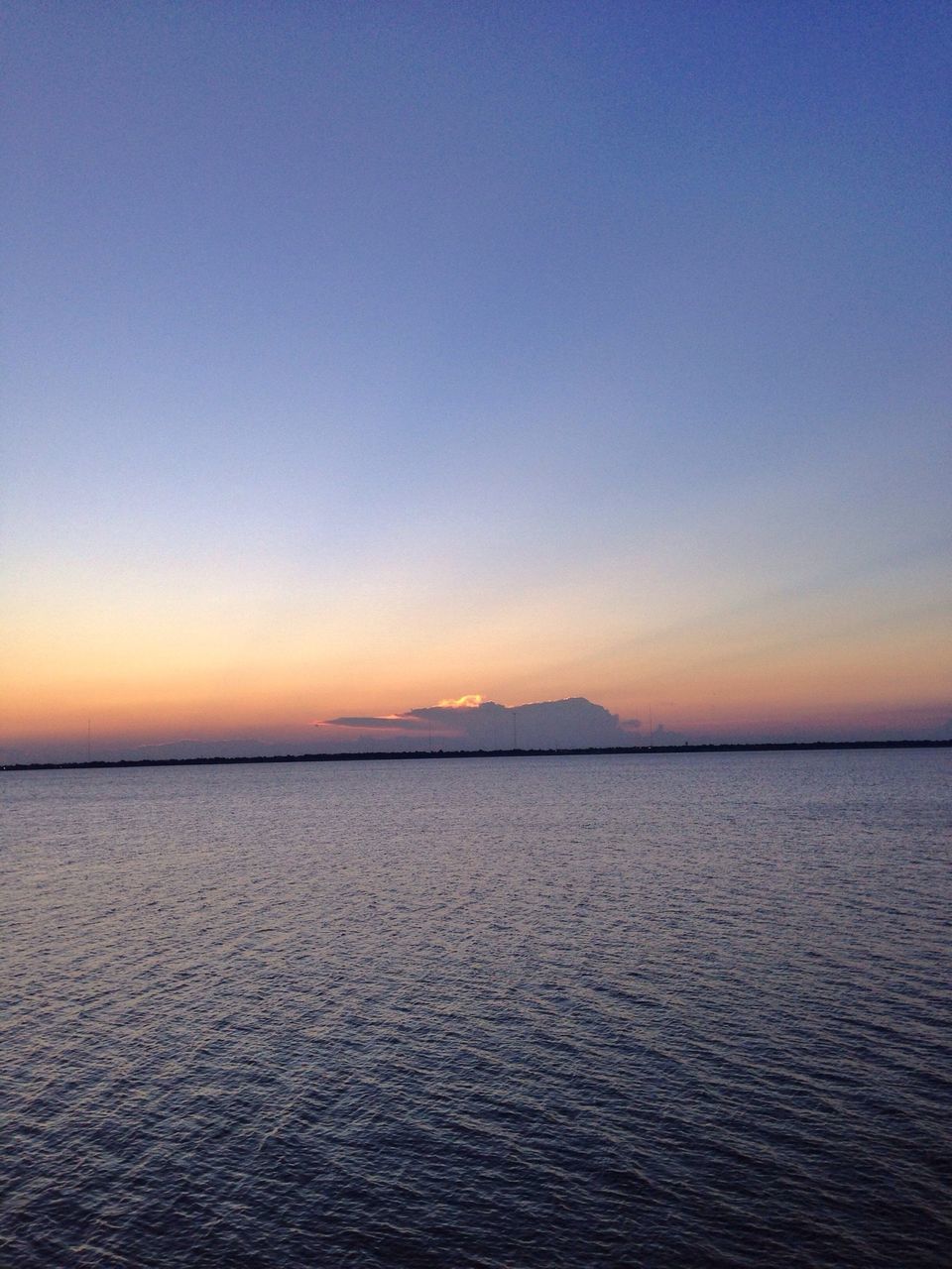 water, tranquil scene, scenics, tranquility, sea, waterfront, sunset, beauty in nature, copy space, clear sky, rippled, nature, idyllic, blue, orange color, horizon over water, sky, outdoors, dusk, calm