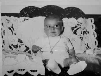 Close-up of cute baby girl sitting at home