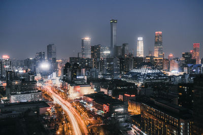 Illuminated cityscape against sky at night