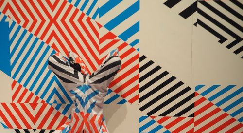 Low section of person upside down against colorful striped wall