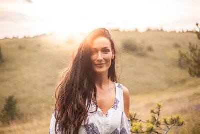 Smiling mid adult woman standing against sky during sunset