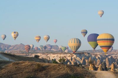 Hot air balloons flying against clear sky on sunny day