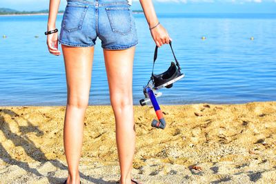 Low section of woman standing on beach